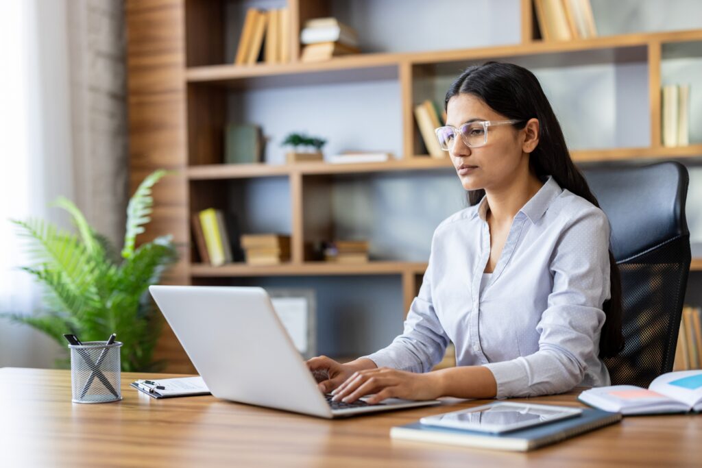 Business professional working on a laptop at an office desk.